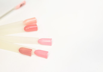 The concept of nail care. Test pastes for nails of pastel tones on a white background.