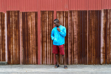 Young happy black African man smiling and thinking while holding