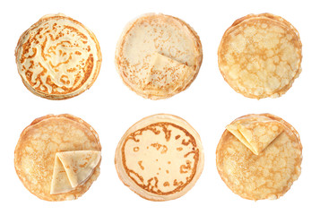 Set of hot tasty thin pancakes on white background, top view