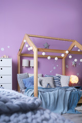 Child's room interior with comfortable bed and garland