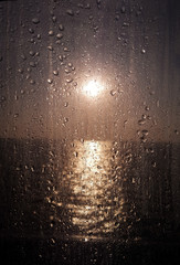 Water drops on the glass window against the beautiful sunset