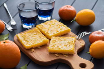 Thai blue tea and lemon pie with fresh citrus fruits on dark background