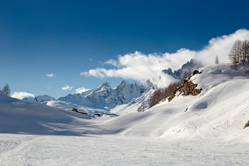 Panoramic view of the sunny snow-covered landscape of the Alpe Sangiatto above the Alpe Devero in Piedmont, Italy.