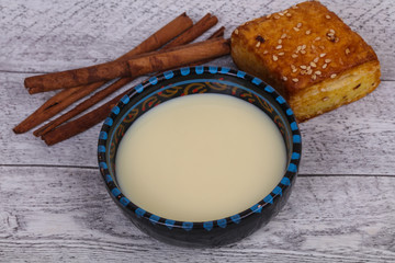 Condenced milk in the bowl with sinnamon and pastry