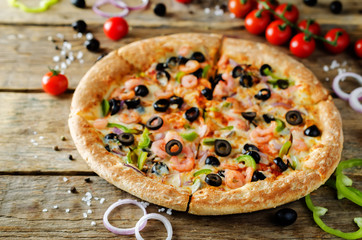Pizza with shrimp, olives, green pepper and onion
