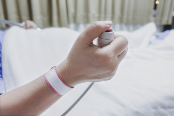 Patient's hand holding an emergency nurse call button