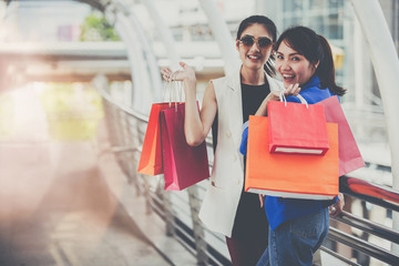 Beautiful young girls with colorful shopping bags over the path way to the shopping mall