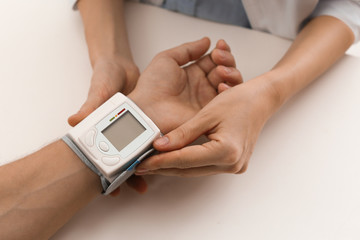 Doctor checking patient's blood pressure in hospital, closeup. Cardiology concept