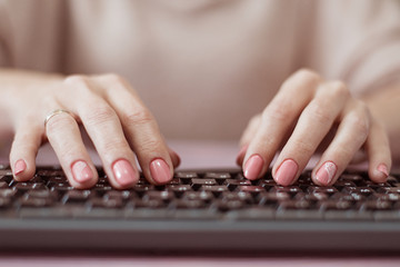 Woman typing on the keyboard. Housewife works at the computer.