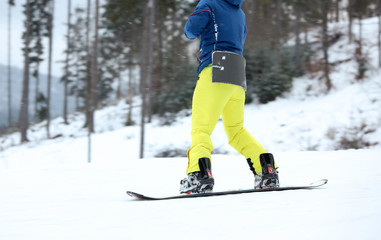 Snowboarder on slope at resort. Winter vacation