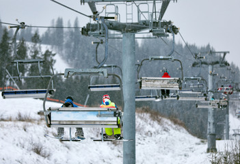 Chairlift with people at ski resort. Winter vacation