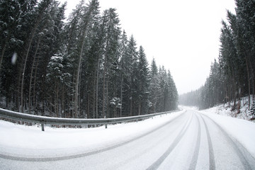 Beautiful landscape with conifer forest and road on snowy winter day