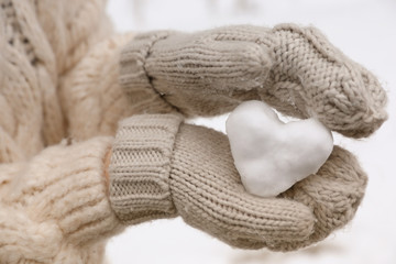 Fototapeta na wymiar Woman holding heart made of snow, closeup view