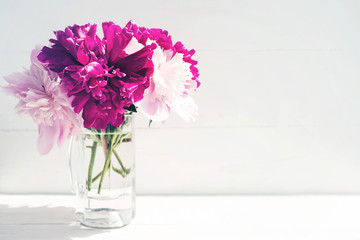 Bouquet of pink peonies in a vase on a white background, close up