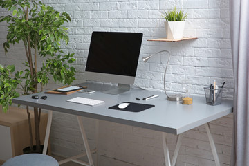 Interior of comfortable work place with computer on table at home