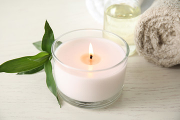 Spa composition with burning candle on table, closeup