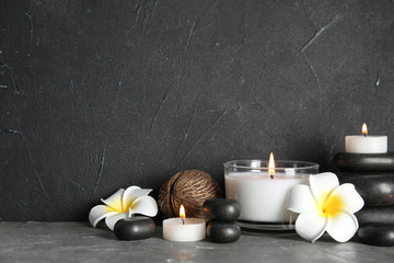 Spa composition with stones and candles on table, space for text