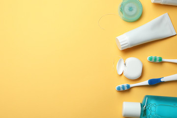 Flat lay composition with toothpaste, oral hygiene products and space for text on color background
