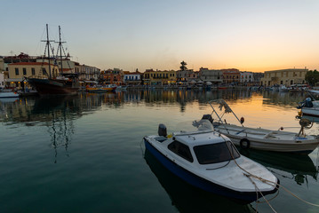 Fototapeta premium Greece, Crete Rethymnon. Old venetian harbor at the evening. Panoramic view on the port and sailing ship.