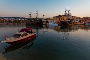 Fototapeta na wymiar Greece, Crete Rethymnon. Old venetian harbor at the evening. Panoramic view on the port and sailing ship.