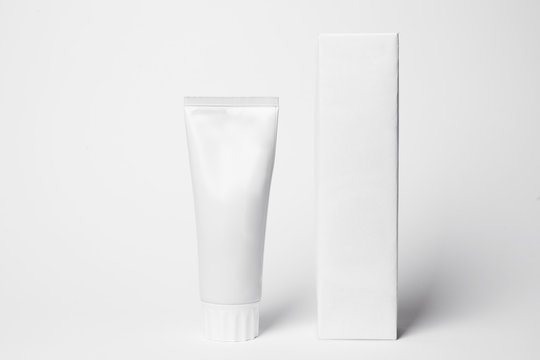 Blank tube of toothpaste and box on white background