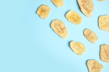 Flat lay composition with banana slices on color background, space for text. Dried fruit as healthy snack