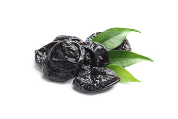 Tasty prunes and leaves on white background. Dried fruit as healthy snack