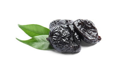 Tasty prunes and leaves on white background. Dried fruit as healthy snack