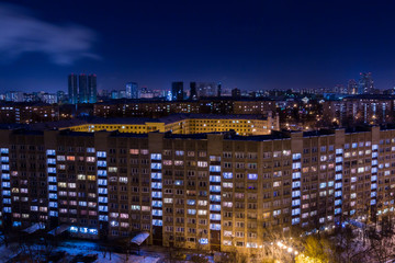 Fototapeta na wymiar Evening or night city landscape. Lights in the Windows of apartment buildings.