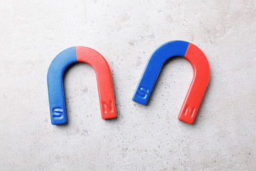 Red and blue horseshoe magnets on grey background, top view