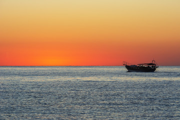 Sunrise on the Mediterranean coast, against the background of fishing boats.