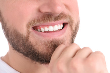 Fototapeta premium Young man with healthy teeth smiling on white background, closeup
