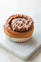 Homemade Fresh Cinnamon Roll / Bun with Cream Sauce served with Marble Board.