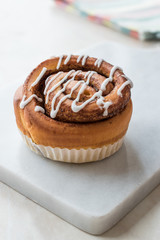 Homemade Fresh Cinnamon Roll / Bun with Cream Sauce served with Marble Board.