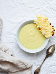 Potato cauliflower soup puree with vegan cheese snack on a white background, top view. Vegetarian healthy food concept
