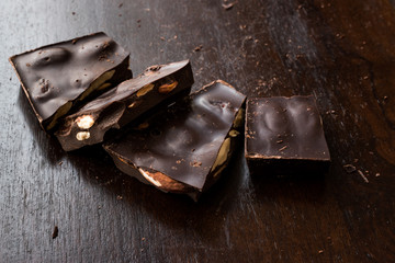 Bitter Almond Chocolate Pieces on Dark Wooden Surface.