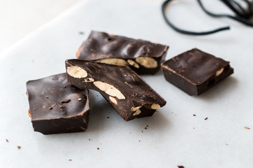 Bitter Almond Chocolate Pieces on White Marble Surface.