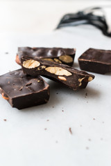 Bitter Almond Chocolate Pieces on White Marble Surface.