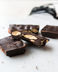 Bitter Almond Chocolate Pieces on White Marble Surface.