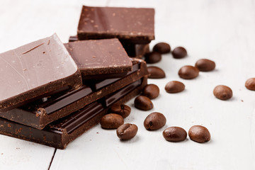 dark chocolate and coffee beans on a white wooden table