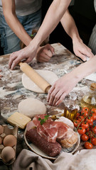 Woman with child preparing dough for homemade pizza. Light toning