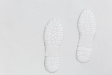 Overhead view of human footprints on white winter snow background. Texture of snow and snowflakes...