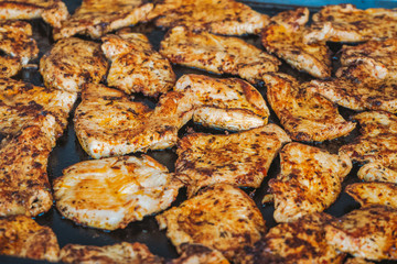 Chicken meat cooking on grill. Closeup view of hot steaming food. Horizontal color photography