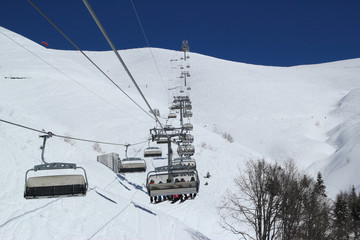 Skiers and snowboarders on chairlift, ski resort Rosa Khutor, Sochi Russia