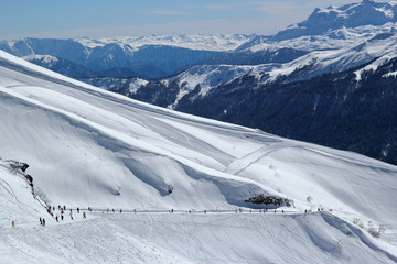 Fototapeta na wymiar Sunny ski slopes of the snowy mountain resort Rosa Khutor, Sochi Russia