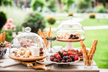 Buffet with different cheeses, grissini and fruits