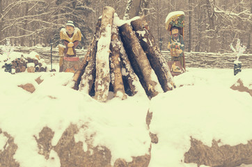 The logs for the fire are lined with stones as temples against the statues of ancient deities.