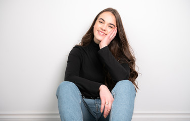 Fototapeta premium Portrait of a charming brunette little girl sit on white background