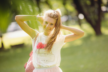 Positive and cute blond girl posing at the park