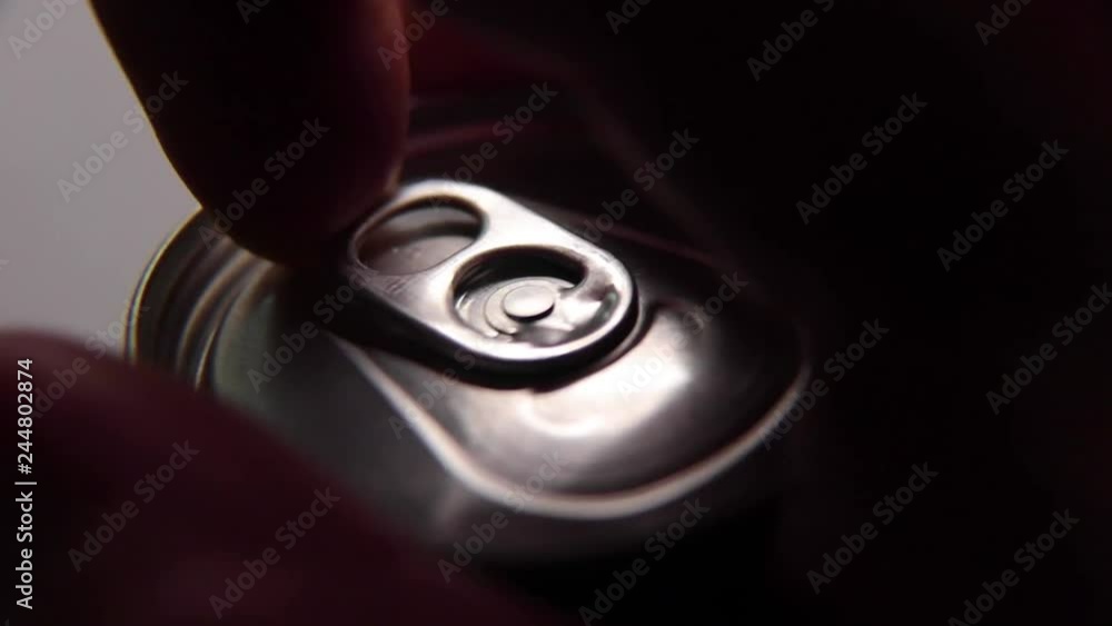 Poster macro footage of drink can being opened and picked up from table. dark liquid visible in the can and